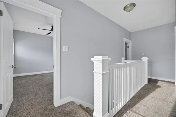 an empty room with a window and a fan