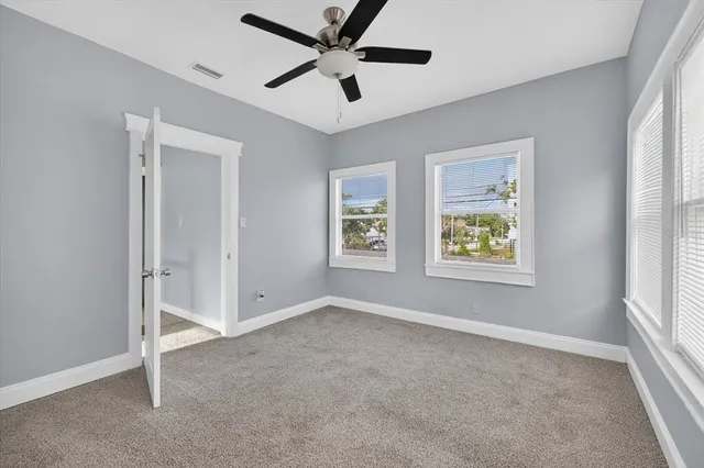 an empty room with chandelier fan