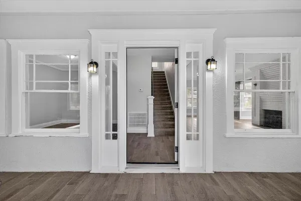 a view of a hallway with wooden floor and staircase