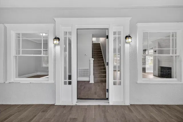 a view of a hallway with wooden floor and staircase