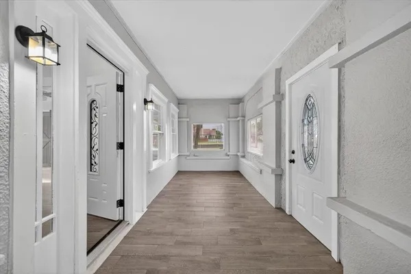 a view of a hallway with wooden floor and closet