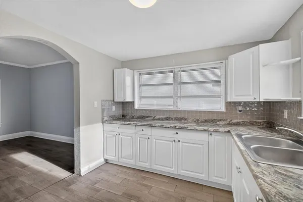 a view of an empty room with a window and fireplace