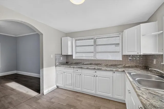 a view of an empty room with a window and fireplace