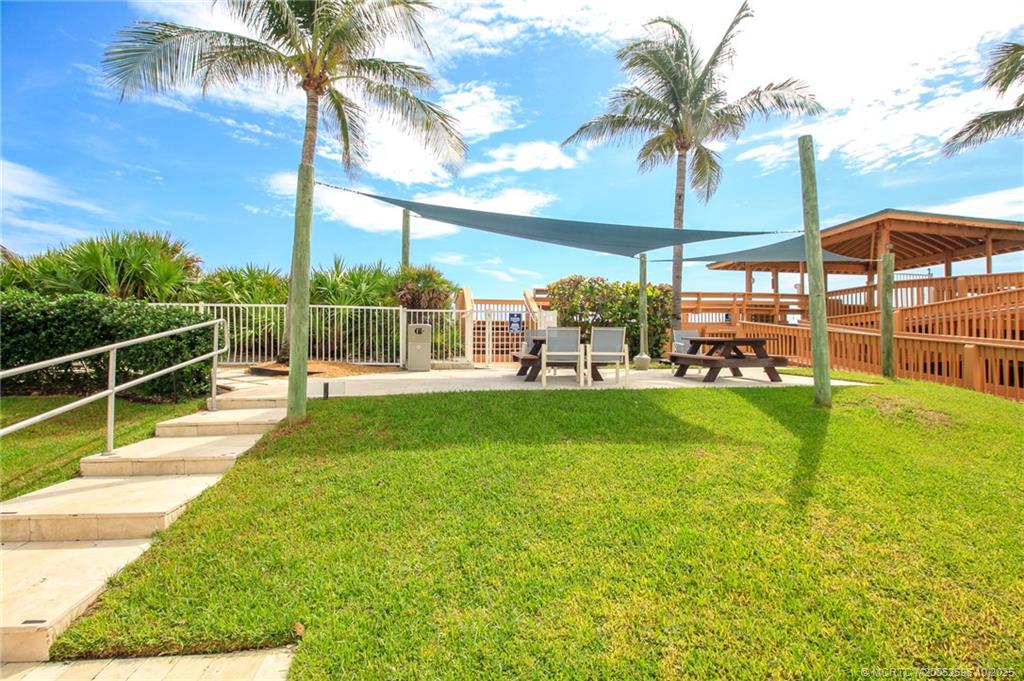 10680 South Ocean Drive, Unit 1005 Jensen Beach, FL 34957 - Photo 35 of 42 a view of a swimming pool with a lawn chairs under an umbrella