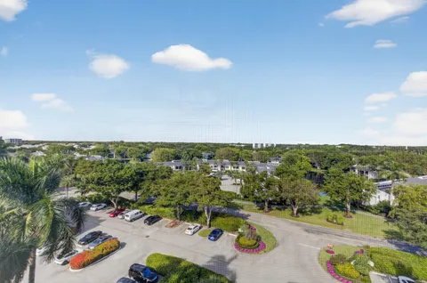 an aerial view of a city with lots of residential buildings ocean and mountain view in back