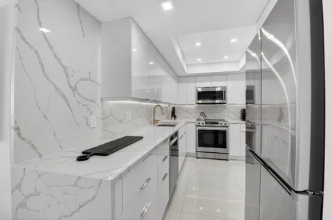 a kitchen with stainless steel appliances a refrigerator sink and microwave