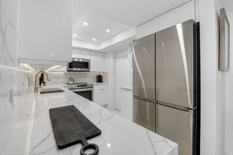 a kitchen with stainless steel appliances granite countertop a sink and a stove