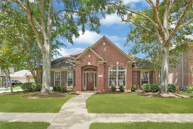 a front view of a house with a garden and yard