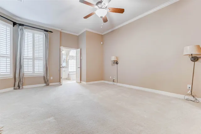 a view of an empty room with chandelier fan and fire place