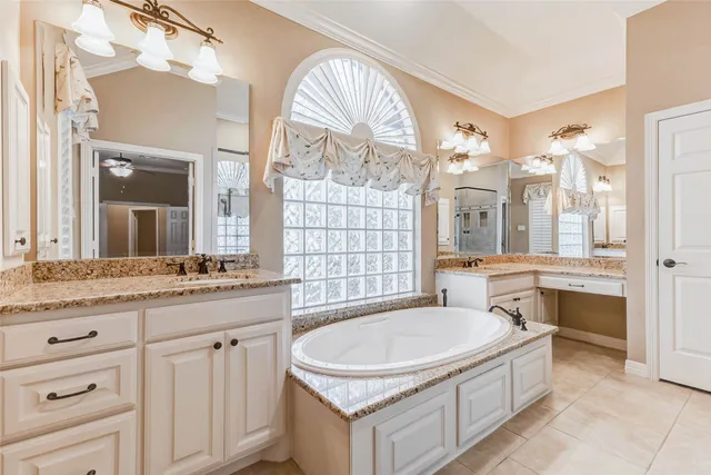 a bathroom with a granite countertop tub a sink and a large mirror