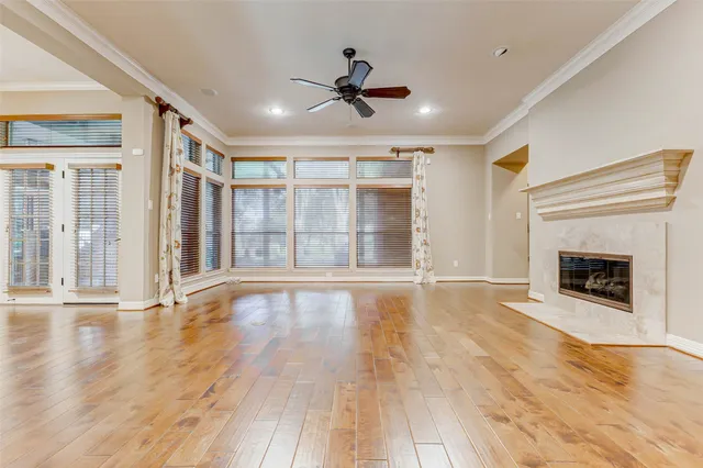 a view of an empty room with wooden floor and a fireplace
