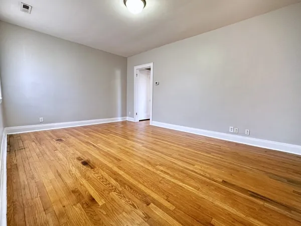 a view of an empty room with wooden floor