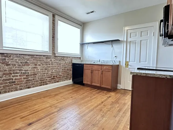a view of a kitchen with wooden floor and a sink