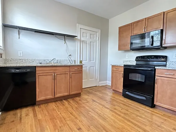 a kitchen with stainless steel appliances granite countertop a stove a sink and a microwave