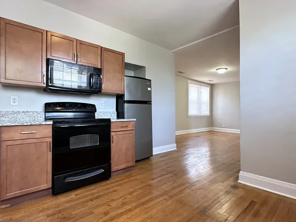 a kitchen with granite countertop a refrigerator stove and sink