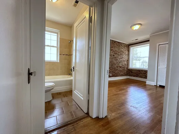 a view of a hallway with wooden floor and a living room