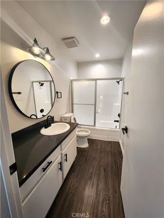 a white toilet sitting next to a white cabinet
