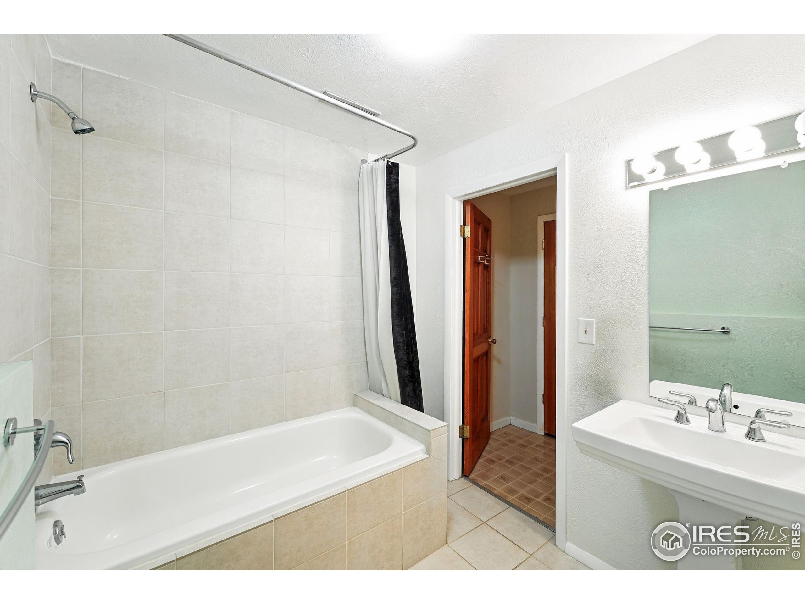 1101 Peakview Circle Boulder, CO 80302 - Photo 32 of 37 a bathroom with a sink a mirror and a bathtub