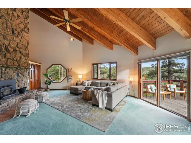 a living room with furniture a fireplace and a large window