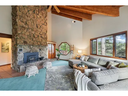 a living room with furniture a fireplace and a large window