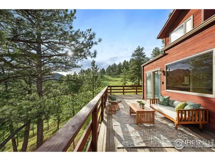 a balcony with wooden floor and outdoor seating