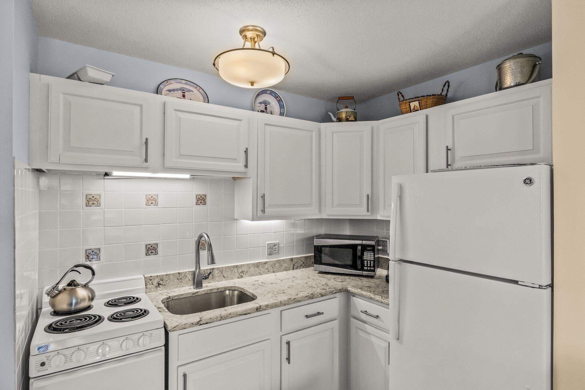 132 Shore Road, Unit 31 Truro, MA 02666 - Photo 5 of 24 a kitchen with refrigerator a stove a sink and cabinets
