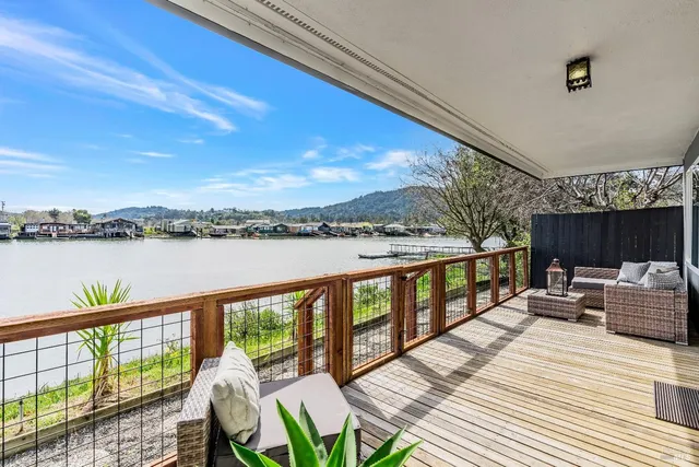 a view of a balcony with lake view and wooden floor