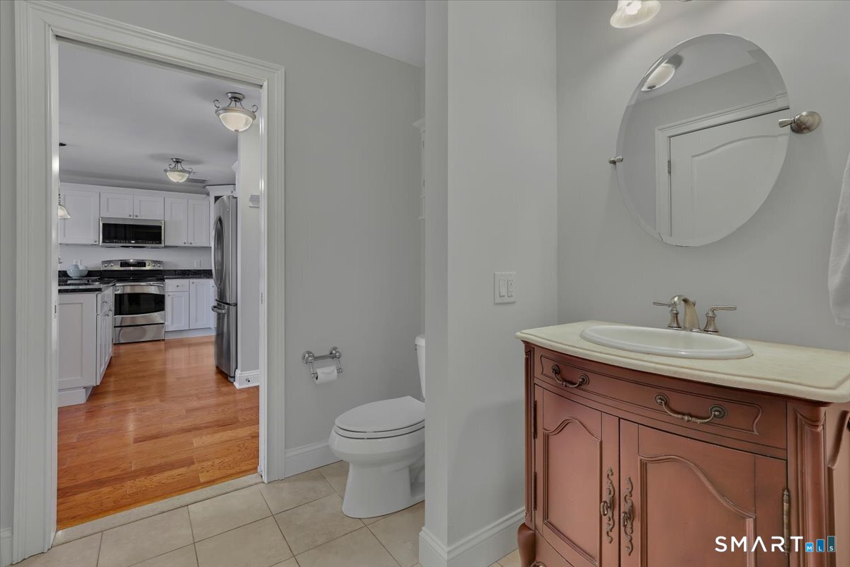 461 Bank Street, Unit 606 New London, CT 06320 - Photo 17 of 35 a spacious bathroom with a granite countertop sink toilet and mirror