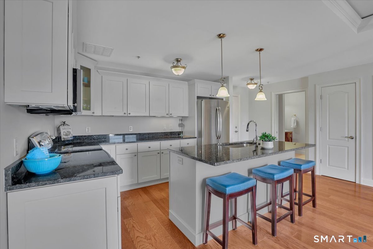 461 Bank Street, Unit 606 New London, CT 06320 - Photo 9 of 35 a kitchen with stainless steel appliances kitchen island granite countertop a sink and cabinets