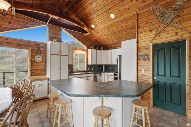 6 Beaver Springs Rancheros Oakley, UT 84055 - Photo 22 of 68 Kitchen featuring wood-paneled walls and ceiling, white cabinetry, a dark countertop island, and tile flooring