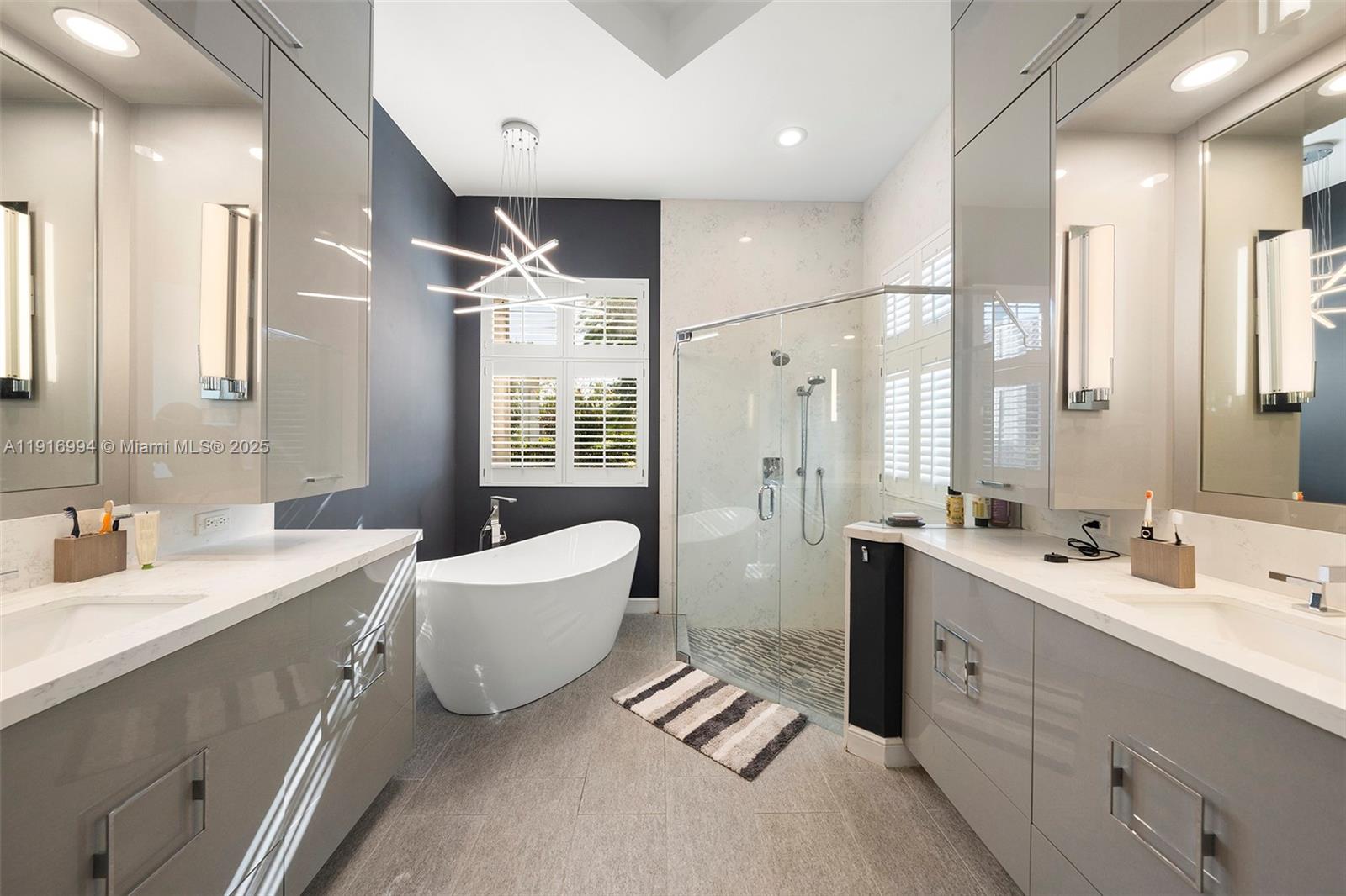 6451 Northwest 32nd Way Boca Raton, FL 33496 - Photo 49 of 54 a bathroom with a double vanity sink mirror and bathtub