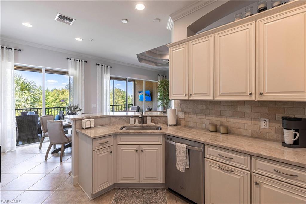 9550 Ironstone Terrace, Unit 201 Naples, FL 34120 - Photo 16 of 50 Kitchen featuring dishwasher, a sink, crown molding, a peninsula, and tasteful backsplash