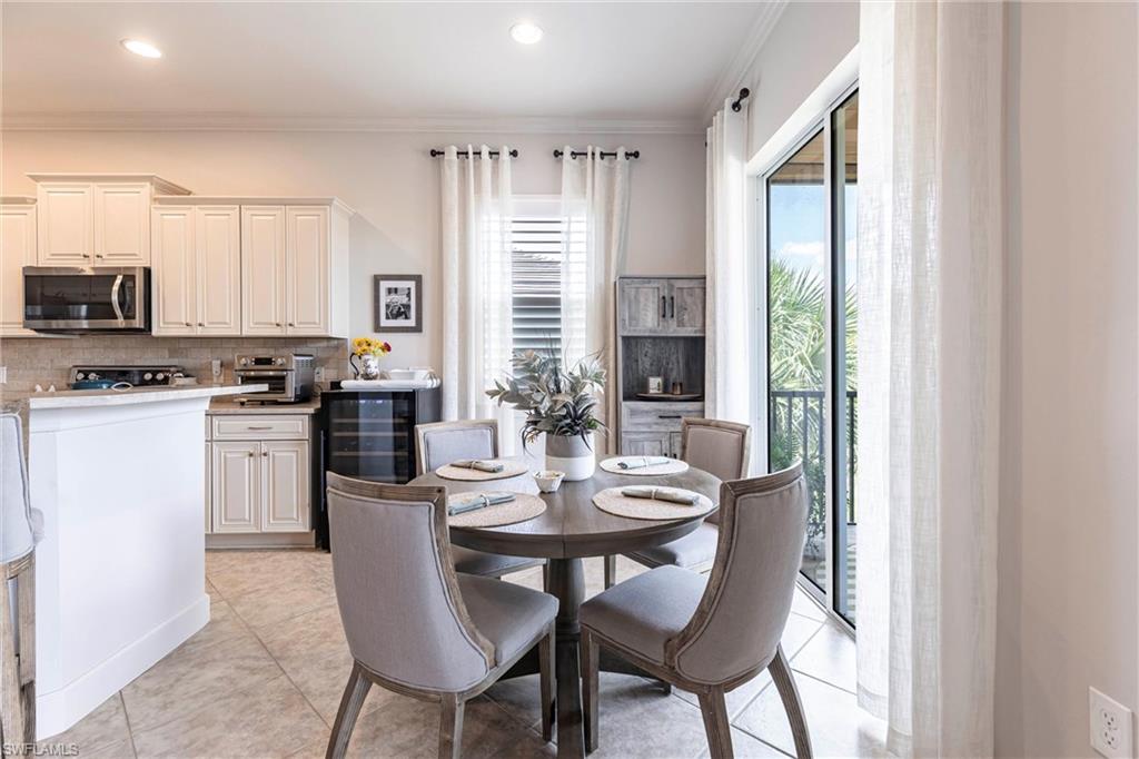 9550 Ironstone Terrace, Unit 201 Naples, FL 34120 - Photo 18 of 50 Dining space with wine cooler, crown molding, recessed lighting, and light tile patterned flooring