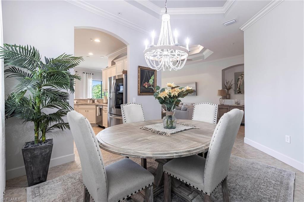 9550 Ironstone Terrace, Unit 201 Naples, FL 34120 - Photo 24 of 50 Dining space featuring a chandelier, crown molding, arched walkways, recessed lighting, and baseboards