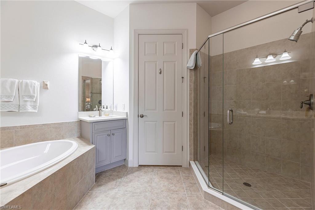 9550 Ironstone Terrace, Unit 201 Naples, FL 34120 - Photo 29 of 50 Bathroom with a stall shower, vanity, a bath, and tile patterned floors