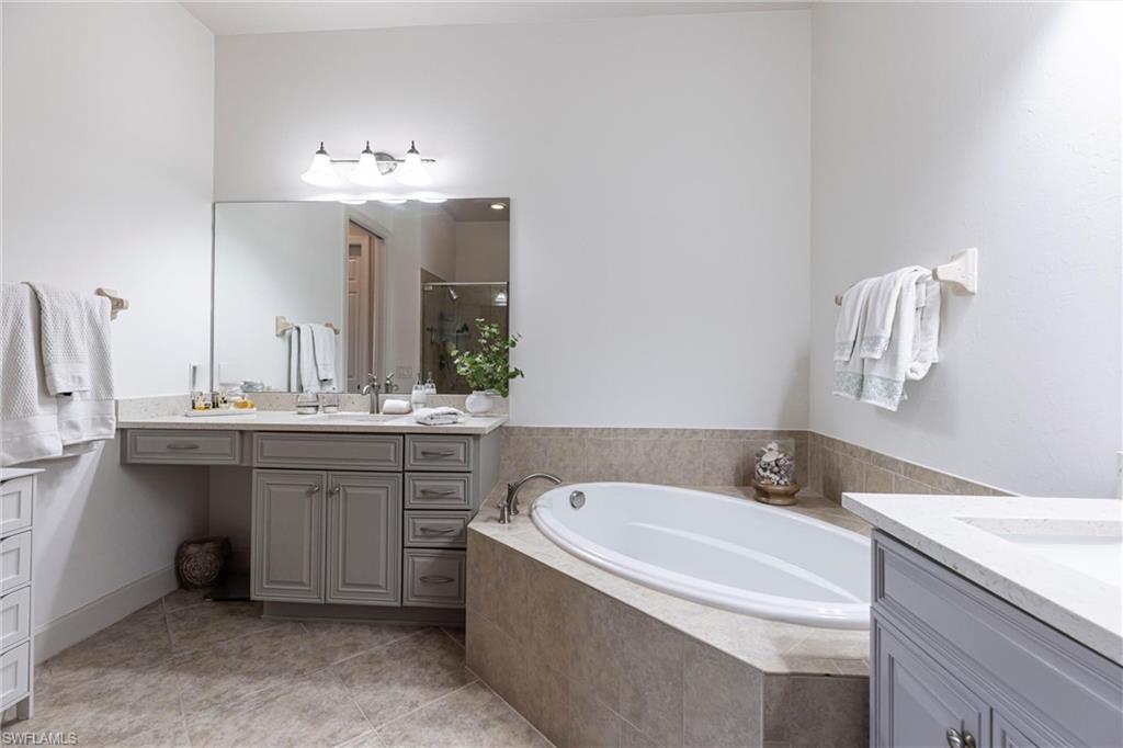 9550 Ironstone Terrace, Unit 201 Naples, FL 34120 - Photo 30 of 50 Full bath featuring a shower stall, two vanities, a bath, and tile patterned flooring