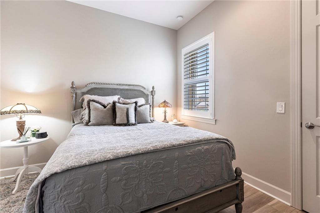 9550 Ironstone Terrace, Unit 201 Naples, FL 34120 - Photo 31 of 50 Bedroom featuring baseboards and wood finished floors