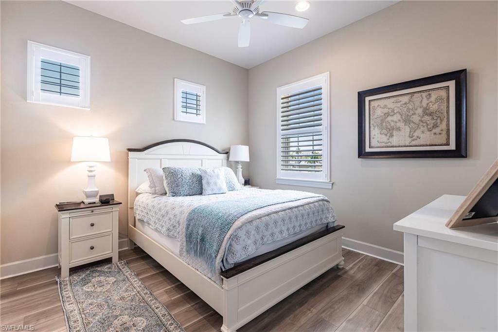 9550 Ironstone Terrace, Unit 201 Naples, FL 34120 - Photo 34 of 50 Bedroom with baseboards, wood finished floors, and ceiling fan