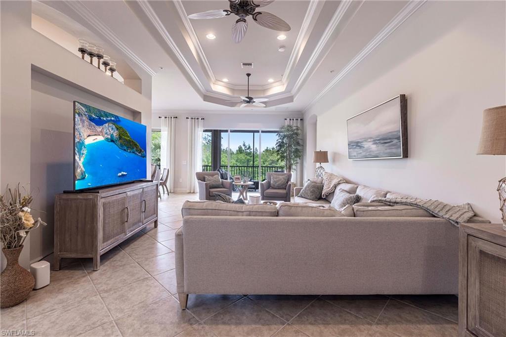 9550 Ironstone Terrace, Unit 201 Naples, FL 34120 - Photo 7 of 50 Living area with ceiling fan, crown molding, light tile patterned floors, a tray ceiling, and recessed lighting