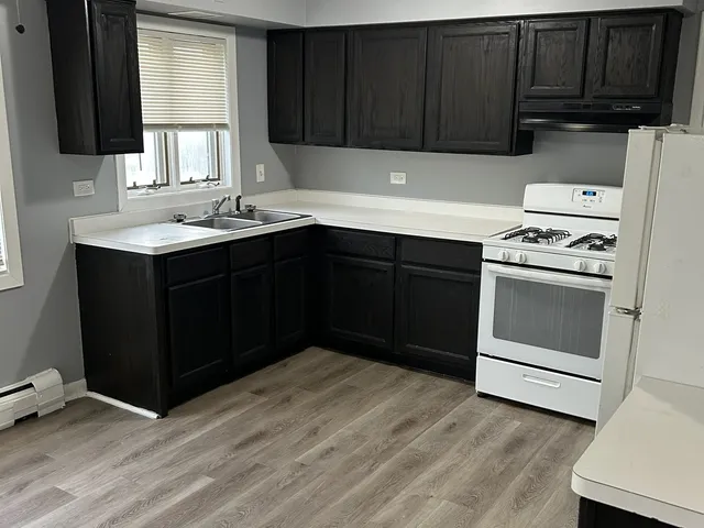 a kitchen with a sink dishwasher stove and cabinets