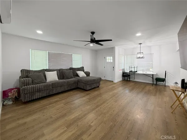 a living room with furniture and a ceiling fan