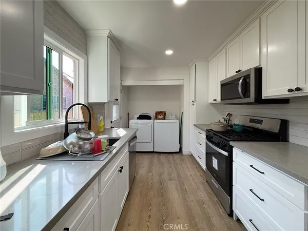 a kitchen with a sink a stove and cabinets