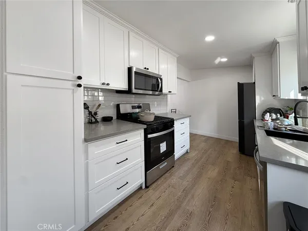 a kitchen with stainless steel appliances a refrigerator sink and cabinets