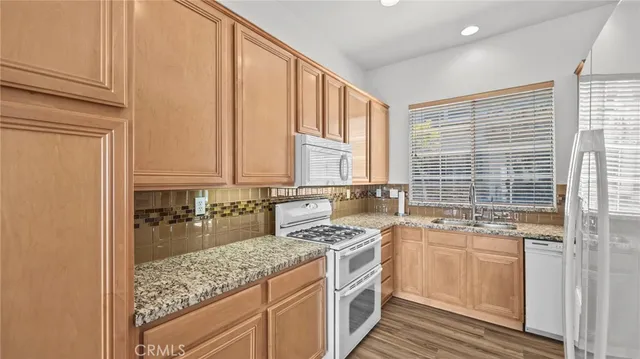 a kitchen with stainless steel appliances granite countertop a sink stove and cabinets