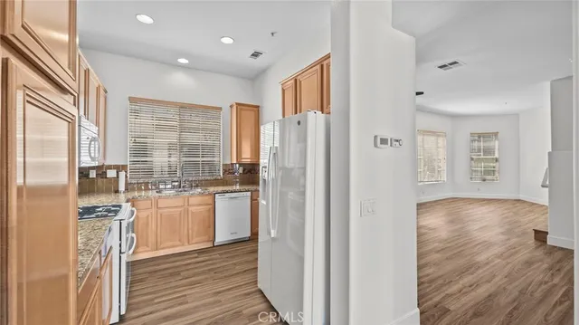 a kitchen with stainless steel appliances granite countertop a refrigerator and a stove top oven