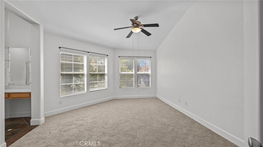 12626 Nicklaus Lane Tustin, CA 92782 - Photo 17 of 36 an empty room with a ceiling fan and windows