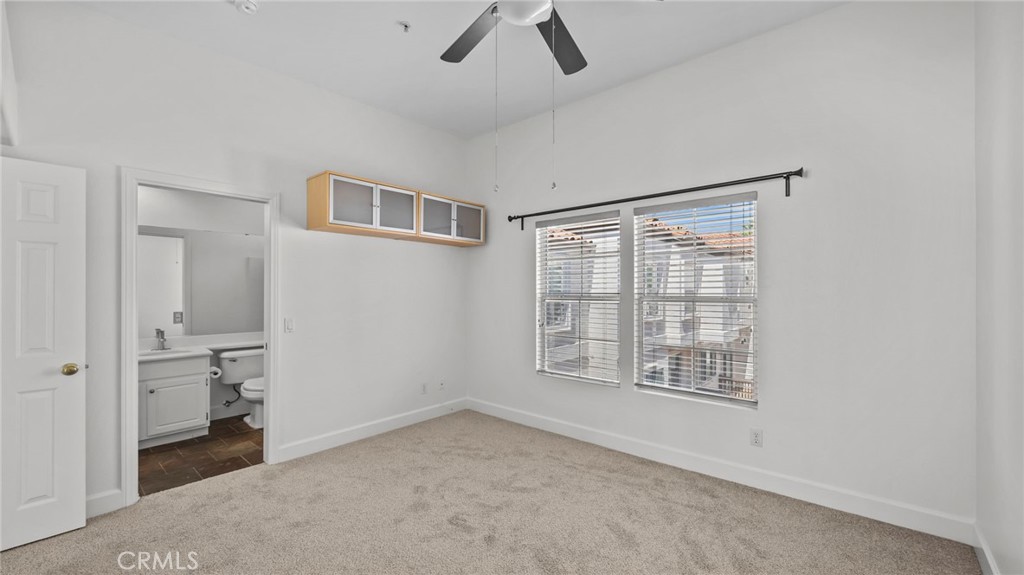 12626 Nicklaus Lane Tustin, CA 92782 - Photo 23 of 36 an empty room with chandelier fan and windows