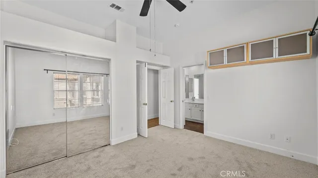 a view of an empty room with chandelier fan and fire place