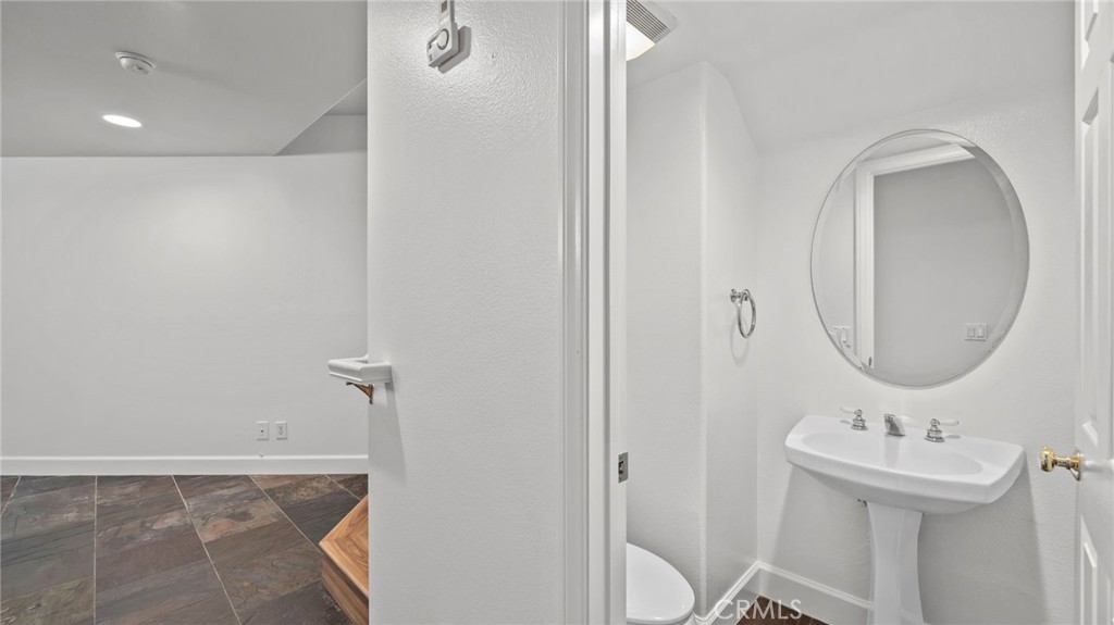 12626 Nicklaus Lane Tustin, CA 92782 - Photo 29 of 36 a bathroom with a sink a toilet and a mirror