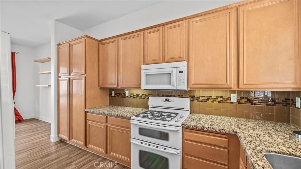 12626 Nicklaus Lane Tustin, CA 92782 - Photo 10 of 36 a kitchen with a stove a sink and a refrigerator